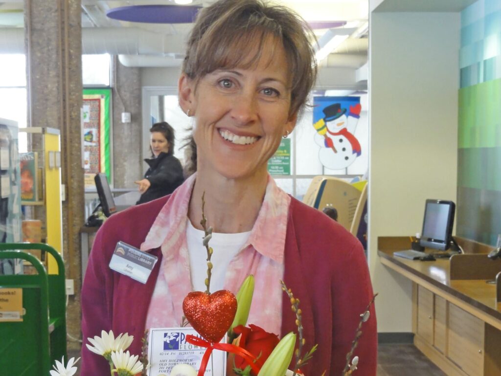 woman holding a bouquet of flowers and smiling for a photo