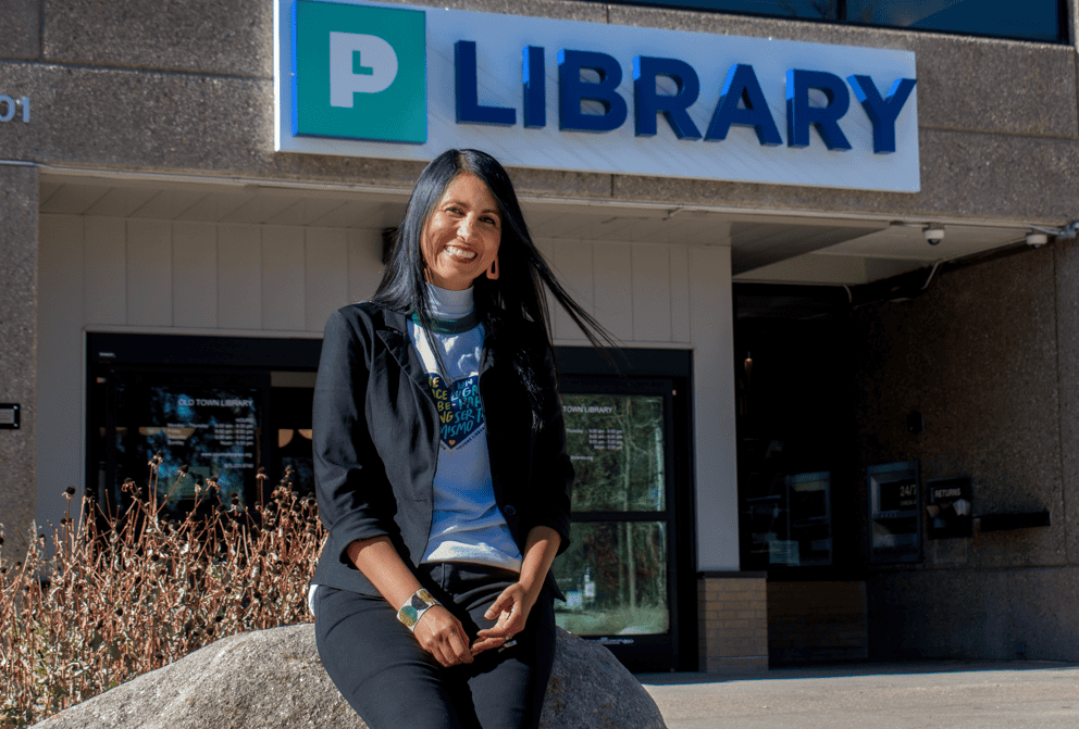 latina woman smiling outside of a library