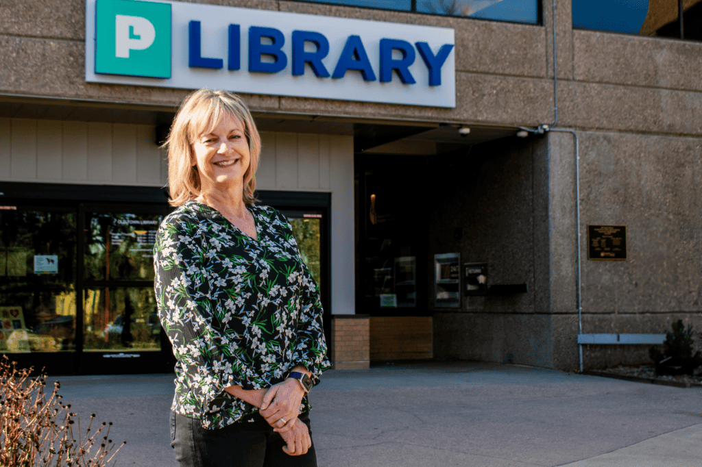 woman smiling in front of a library
