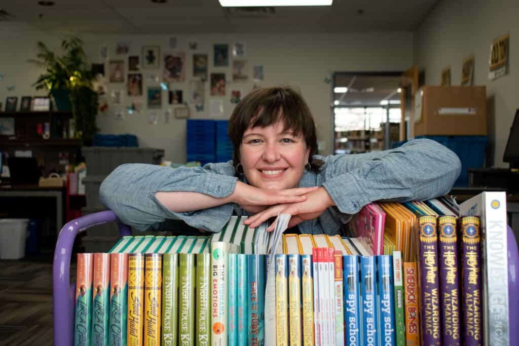 Woman smiling with a book cart