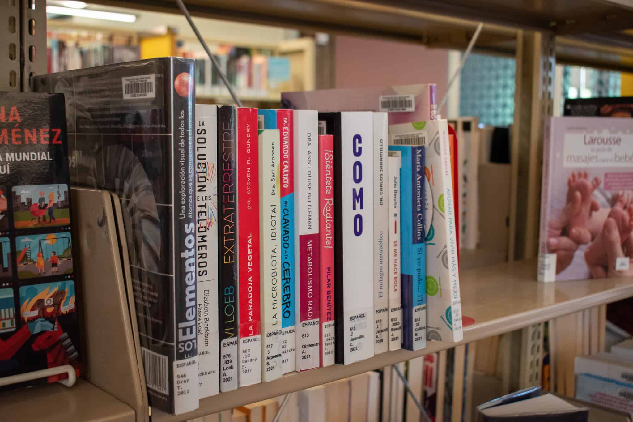 Spanish Language books with colorful spines on a shelf in a library