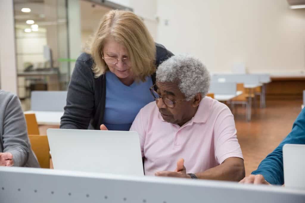 Older woman and older man looking at a laptop computer screen together