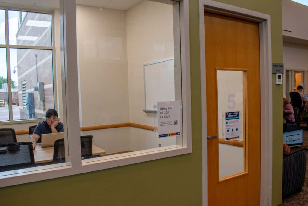 Small study room with the number 5 engraved on a glass and wooden door