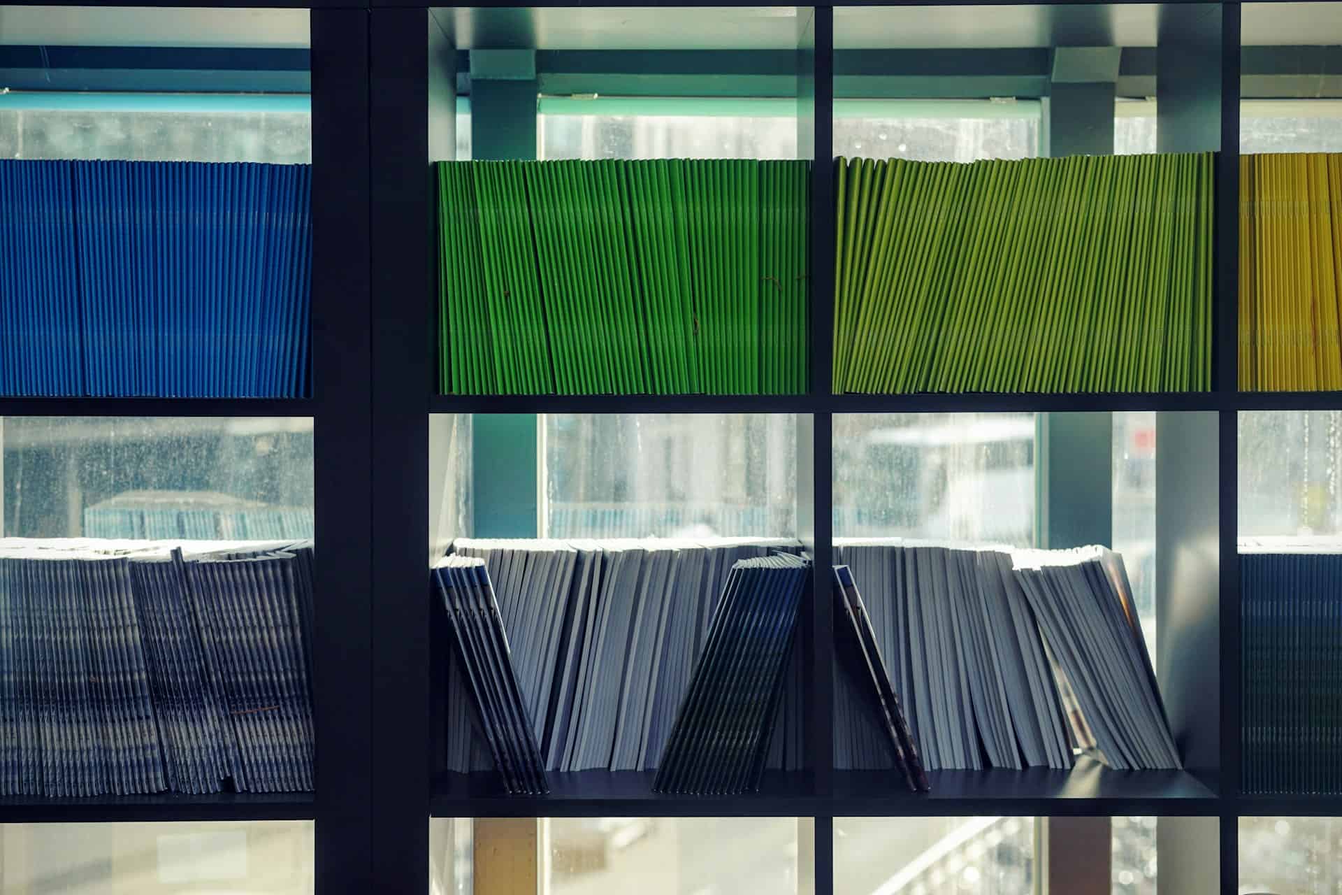 colorful folders in stacks on a black bookshelf