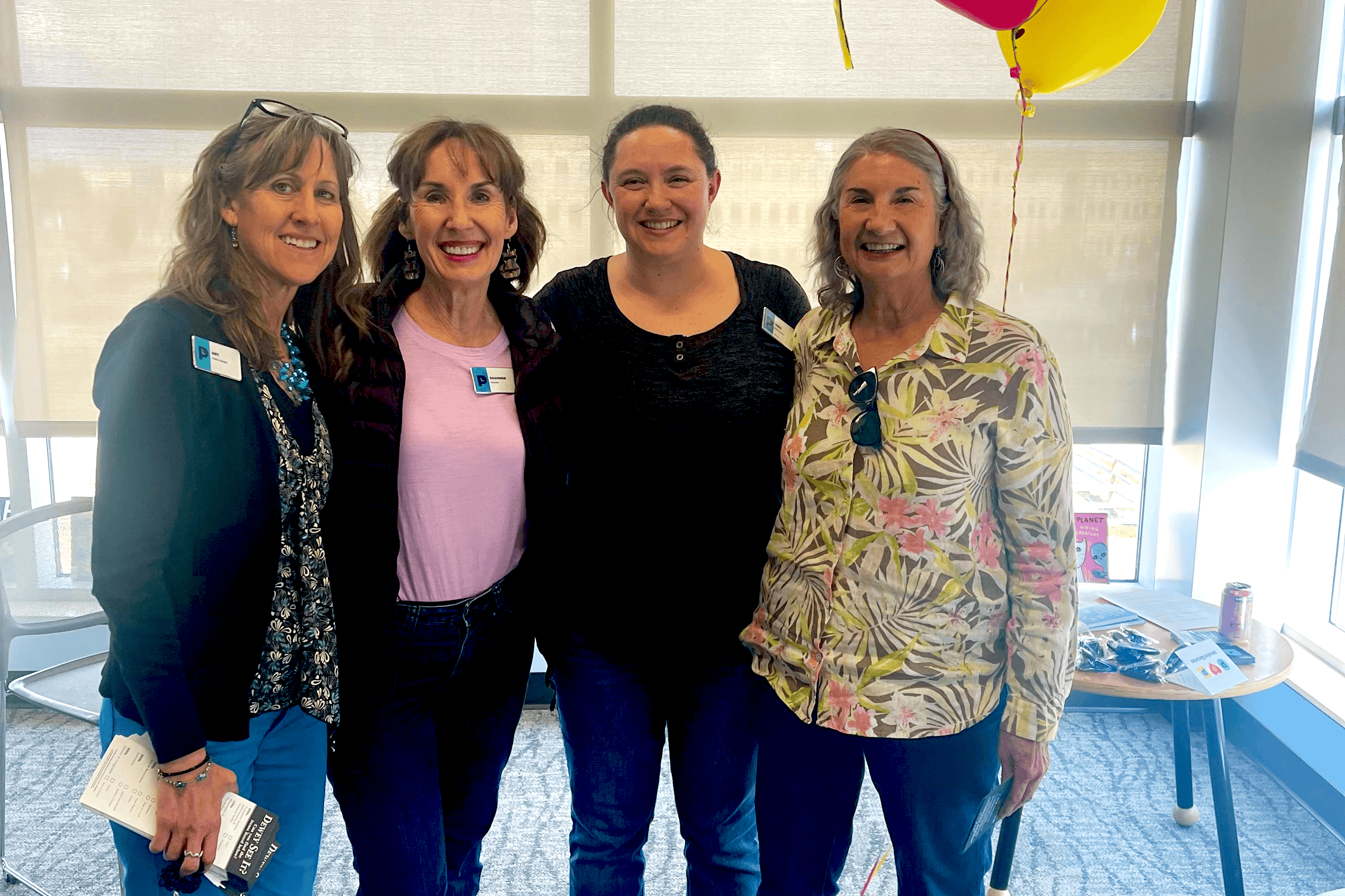 Four women smiling for a photo