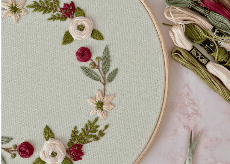 Flower embroidery on a hoop with strong and scissors next to it