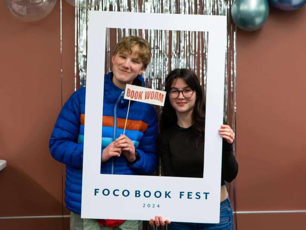 Two teens smile and pose for a photo