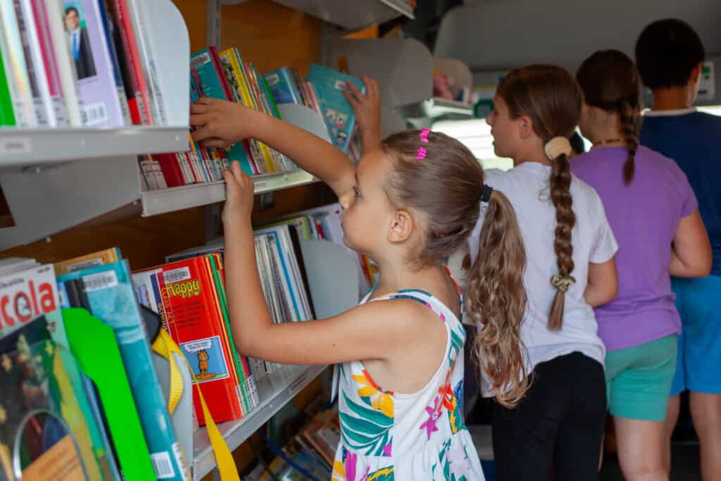 Young girls browsing books inside a library bookmobile