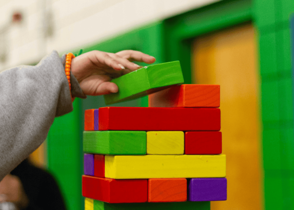 Child's hand stacking blocks