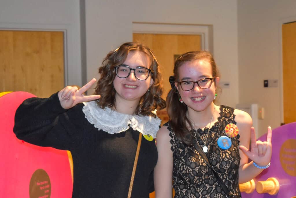 Two teen girls with glasses smiling for a photo