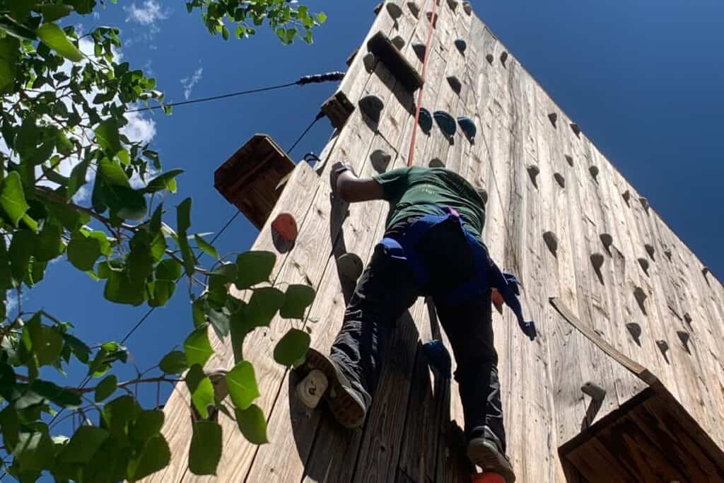 A person climbing an outdoor climbing wall