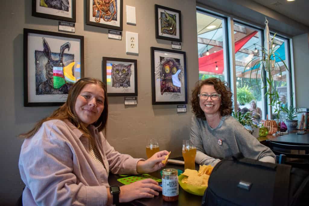 Two women eating at a table and smiling for a photo