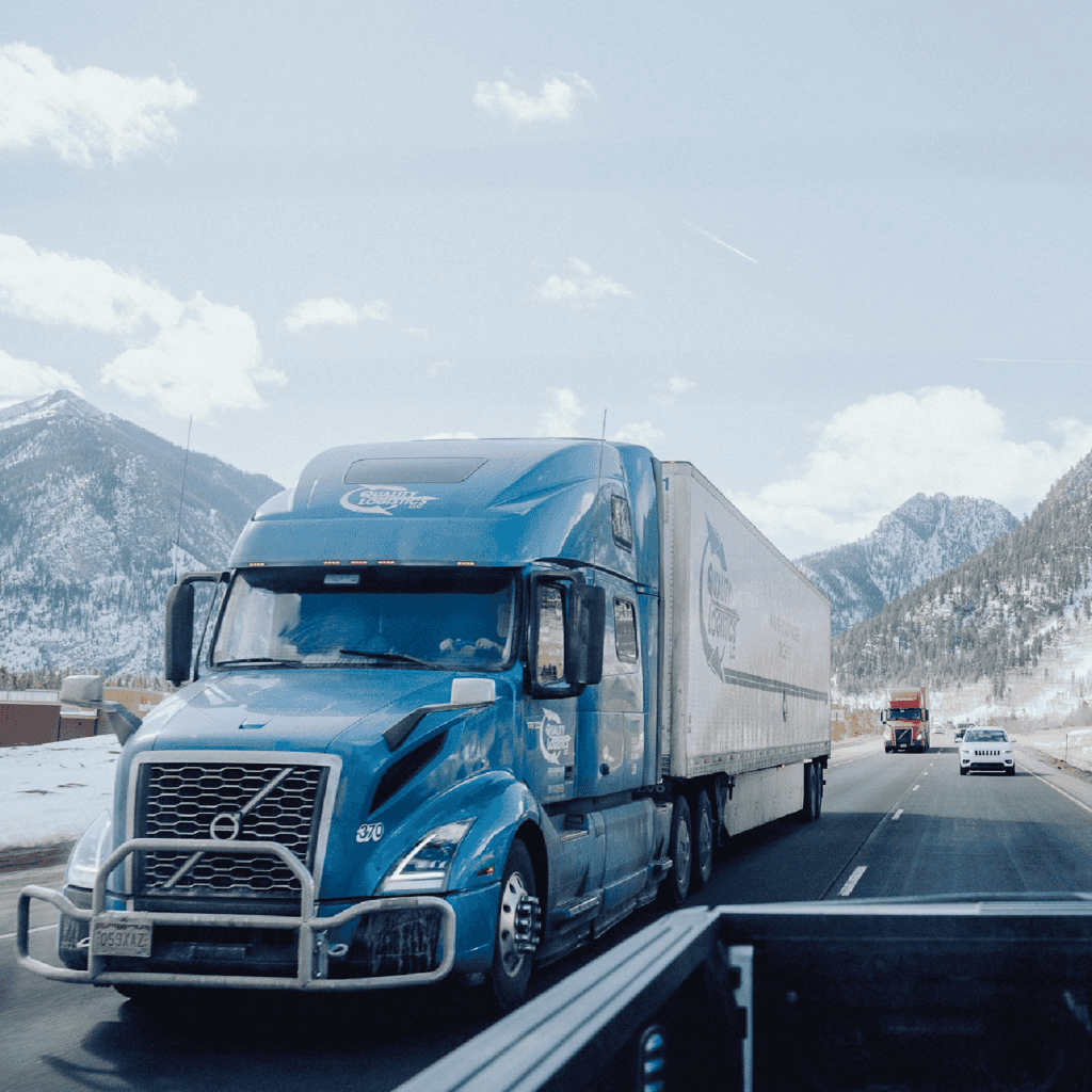 Large blue semi truck driving on a mountain highway