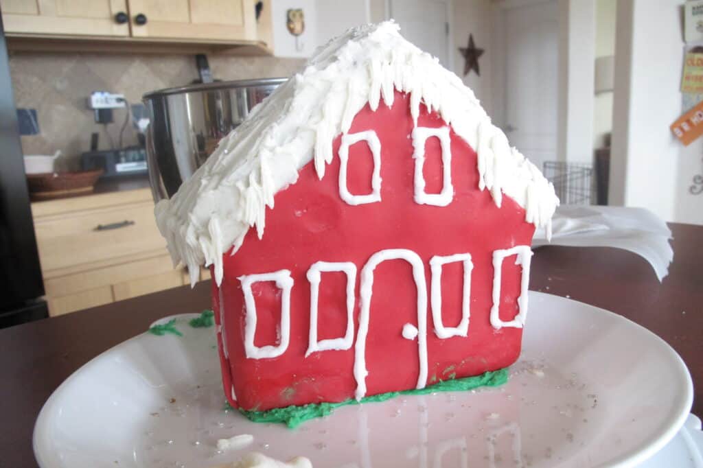 Un pastel de casa de invierno glaseado en rojo