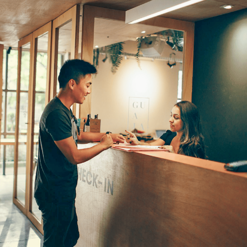 Woman receptionist talking to a man at a hotel check-in desk