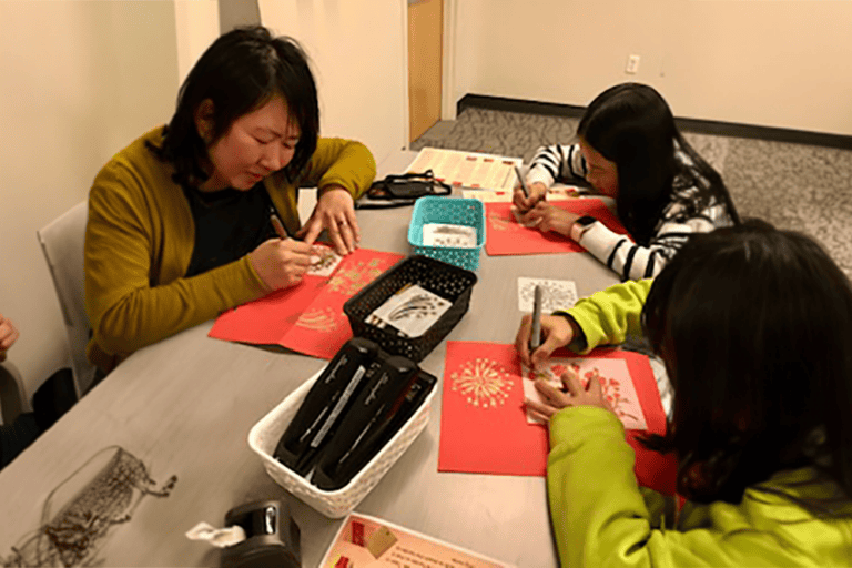 Mother and two daughters completing a craft at a library