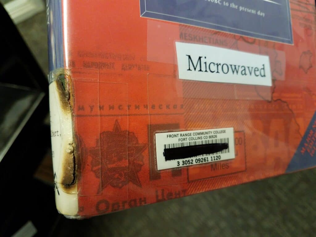 Book with a burnt spine and a label reading "microwaved"