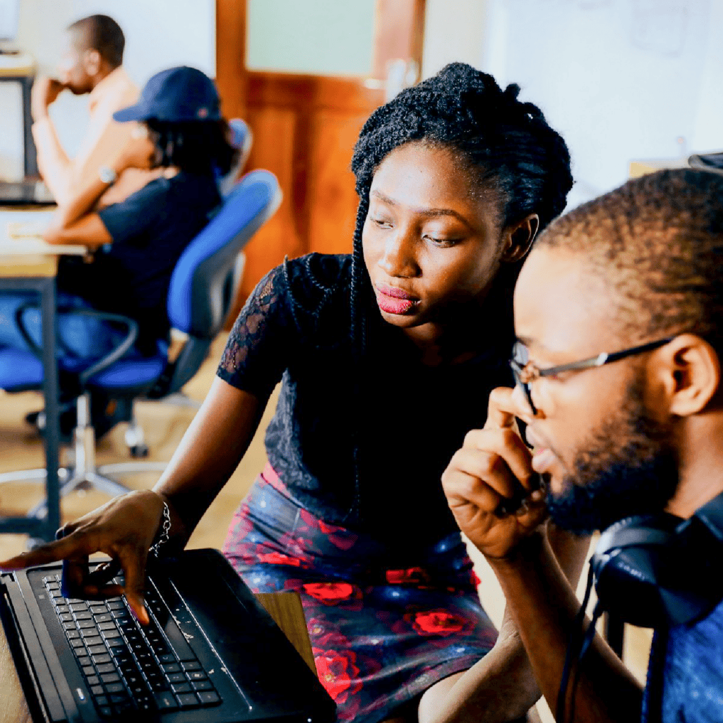 Woman pointing to a computer screen next to a man looking at the screen