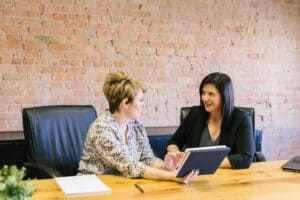 Two women talking and sitting at a table