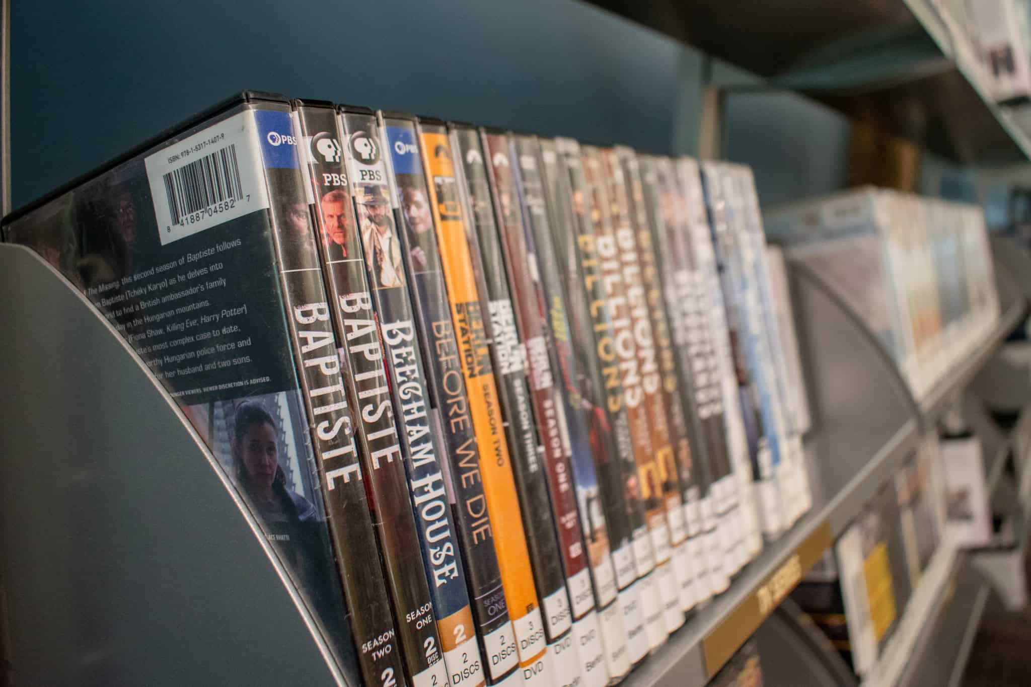 Variety of DVDs arranged on a library shelf