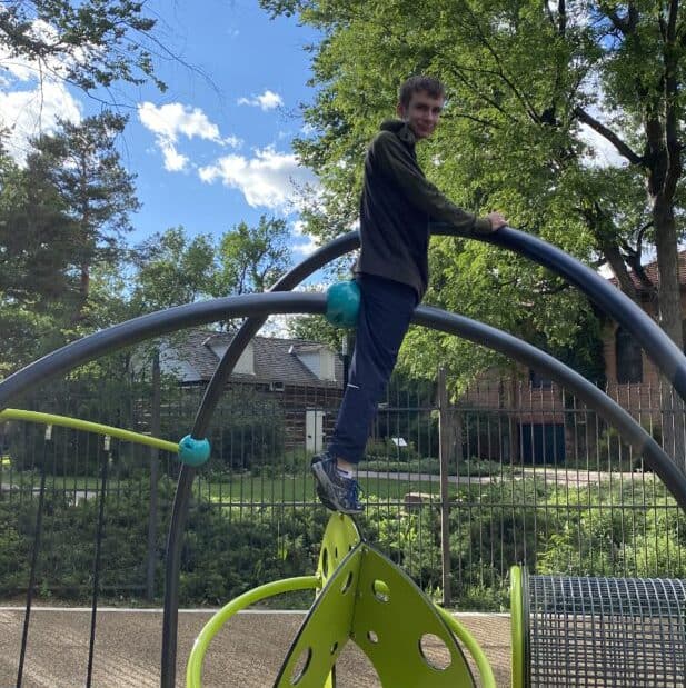 Young boy standing on a playground set