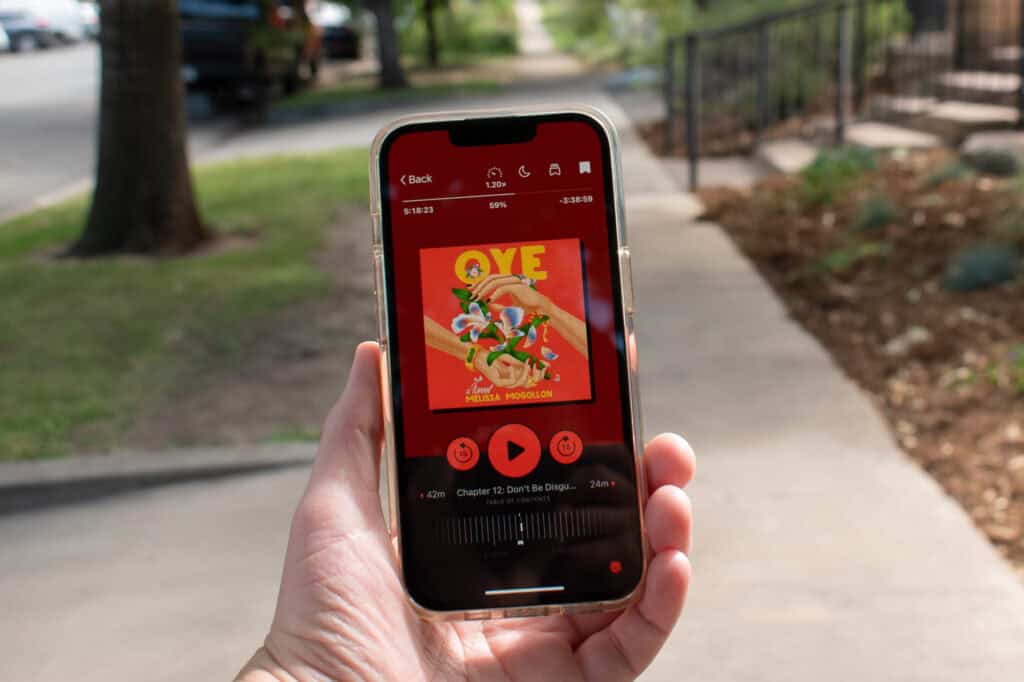 Hand holding a phone displaying an audibook in the Libby app