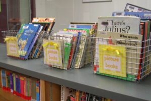 Baskets of children's books sitting on a shelf