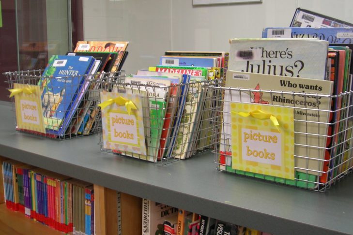 Baskets of children's books sitting on a shelf