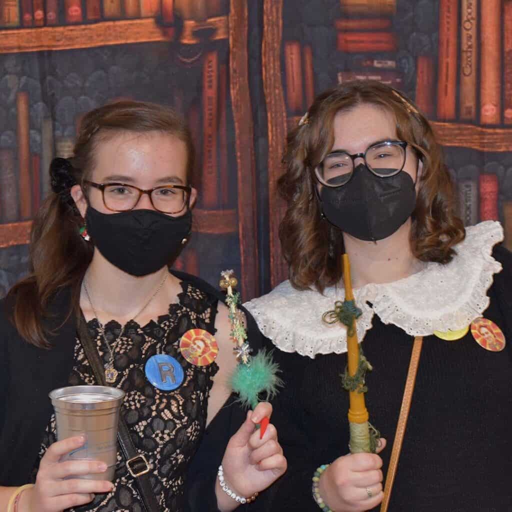 Two teenage girls wearing masks at a library event