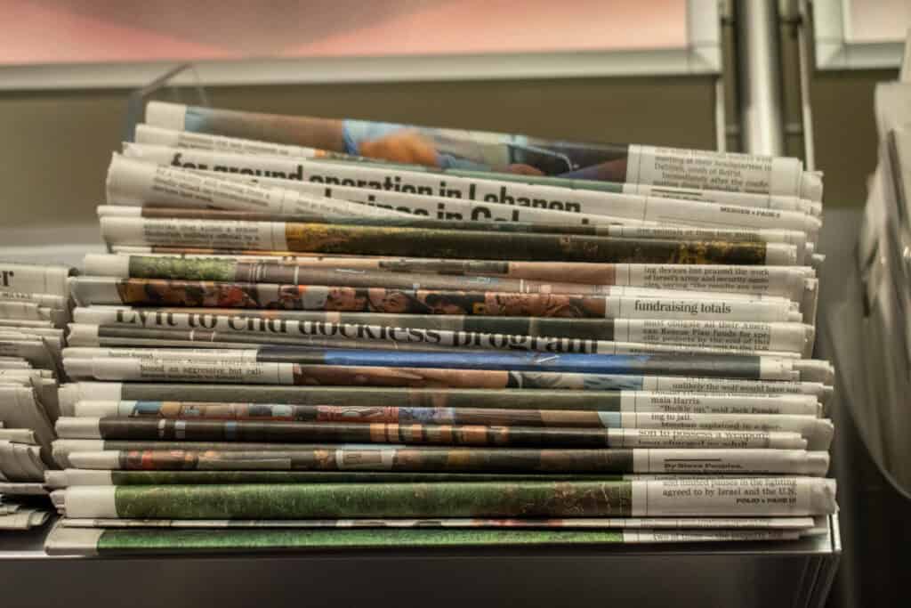 stack of newspapers sitting on a shelf