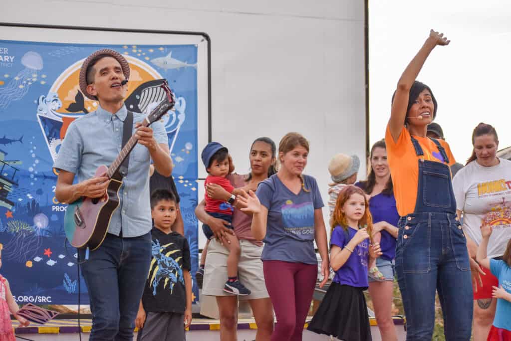 asistentes y artistas bailando juntos en un escenario