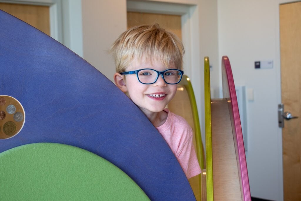 young boy with glasses smiling for a photo