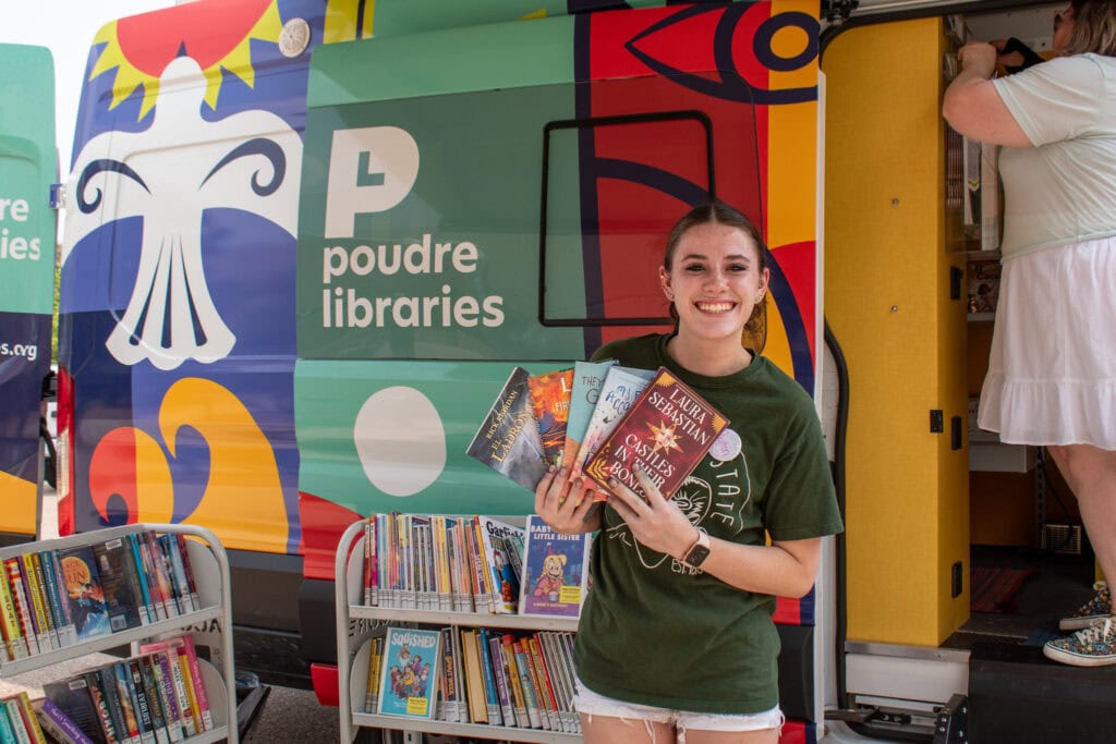 Young woman smiling with an array of books
