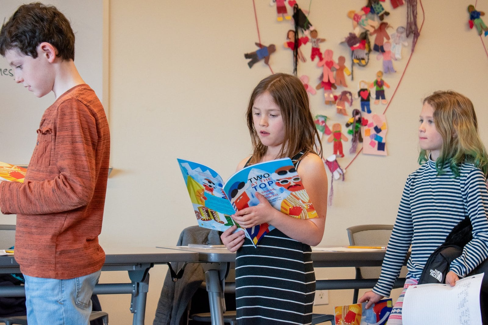 Young girl standing and reading a picture book