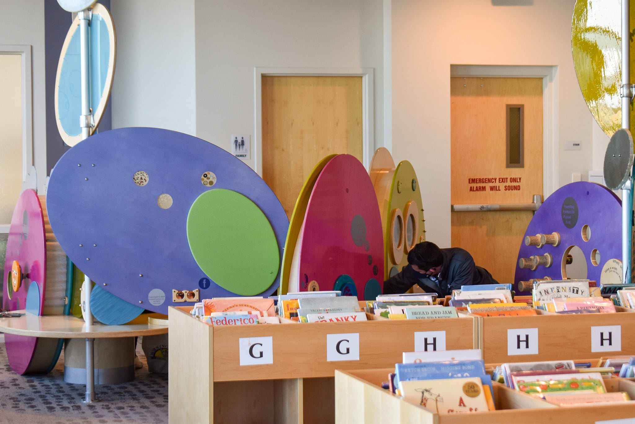 colorful circular structures and bookshelves in the children's section of council tree library